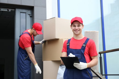 Smiling movers with a branded van in Greenwich